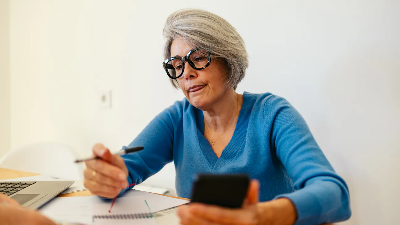 Senior woman using a smartphone at a table