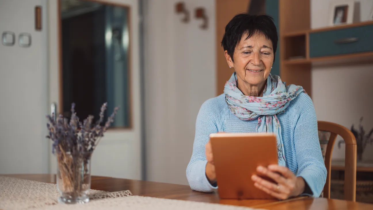 Senior woman researching Medicare options on a tablet at home