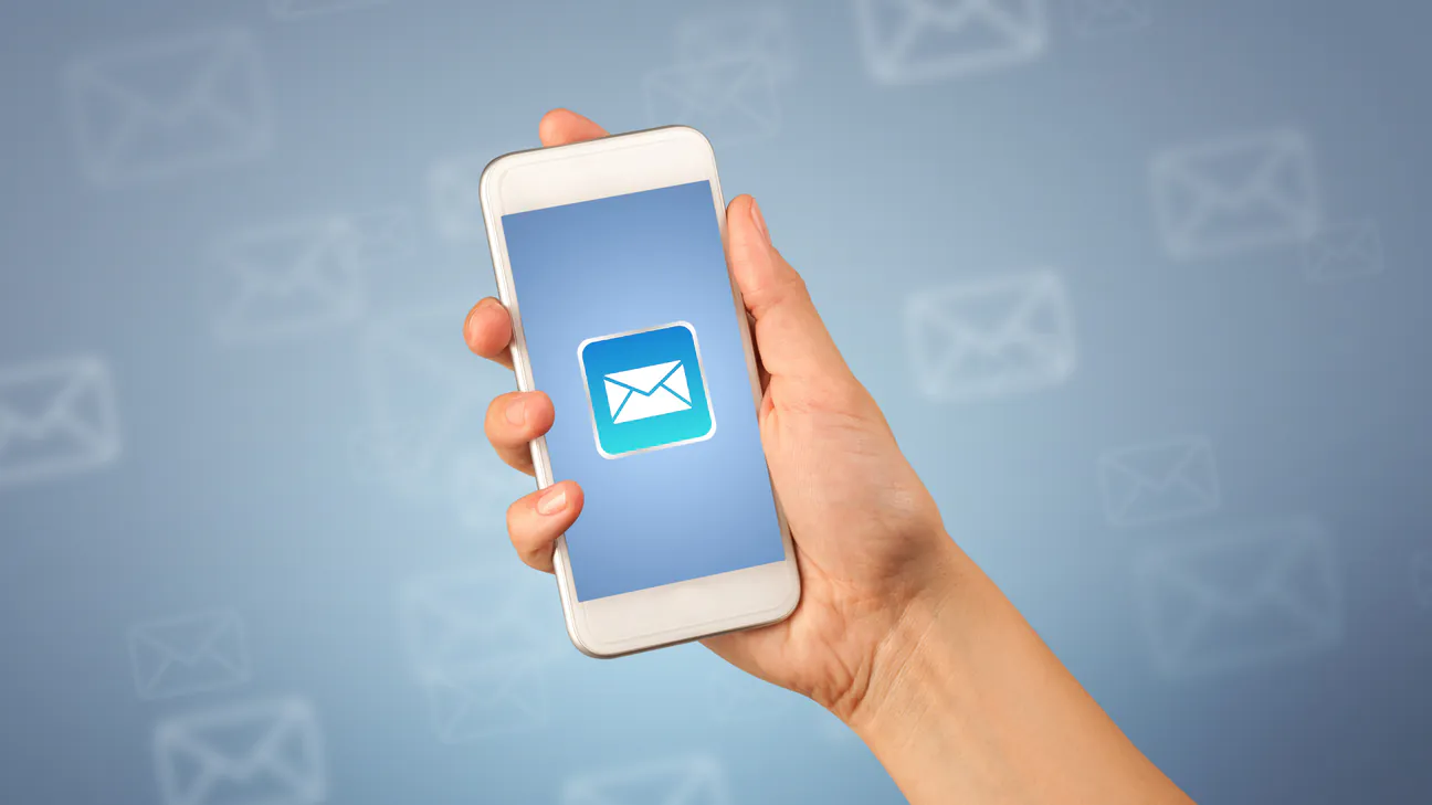 Hand holding a smartphone showing a new email notification