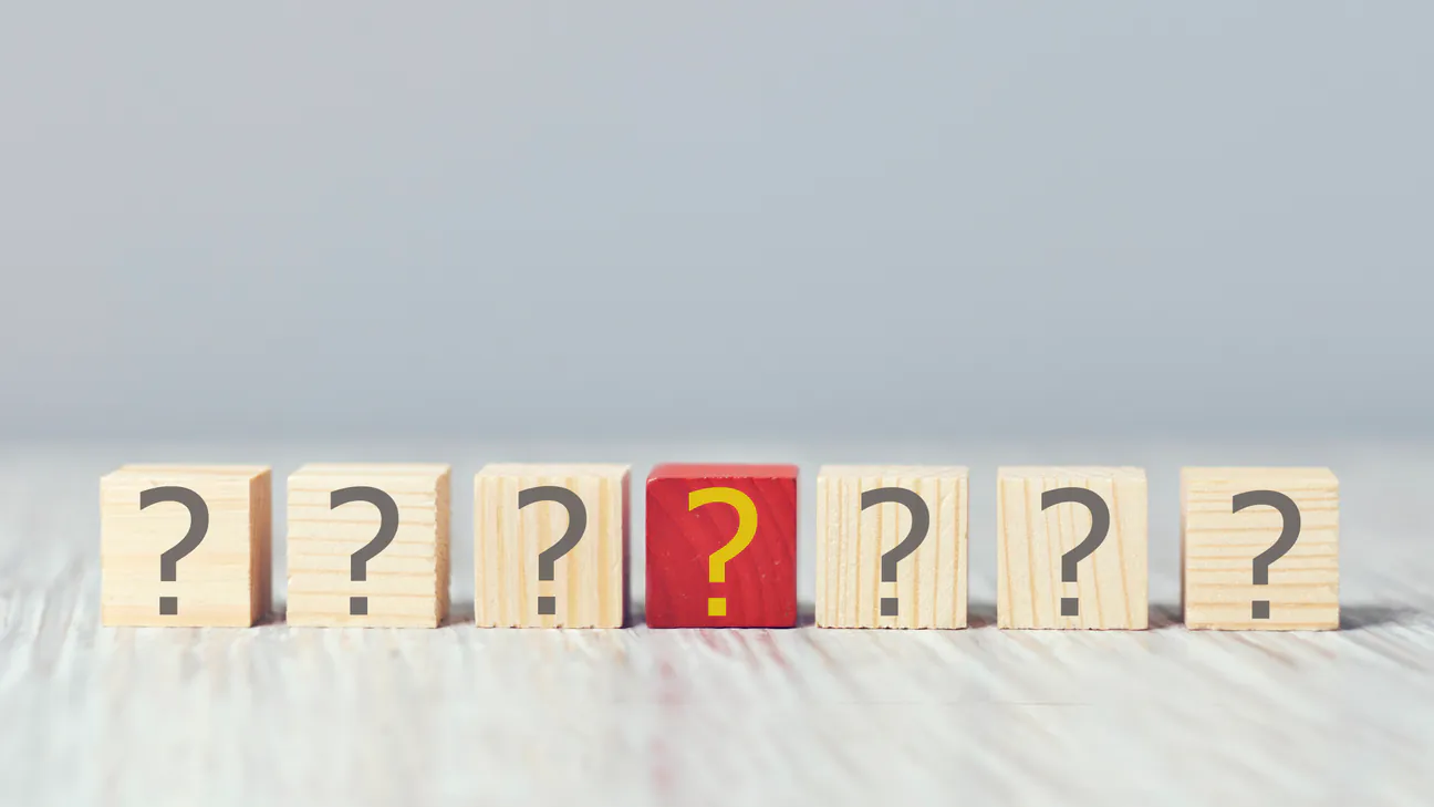 Wooden blocks with question marks on a table